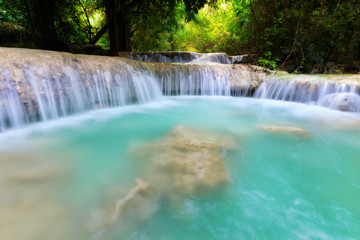 Waterfall in the jungle with lush greenery in the rainy season.