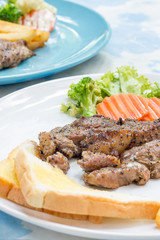 Grilled steak with french fries and vegetables and toast