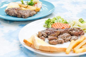 Grilled steak with french fries and vegetables and toast