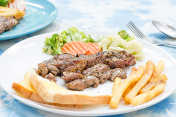 Grilled steak with french fries and vegetables and toast