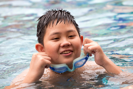 Cute happy boy swimming