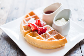 food backgroud -waffle with strawberry sauce on wooden table