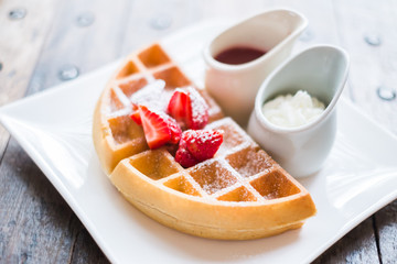 food background -waffle with strawberry sauce on wooden table