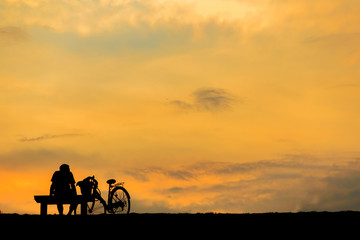 Fototapeta na wymiar silhouette of man relax with bike happy time sunset