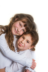 studio portrait of two young happy smiling girls, sisters, over white background