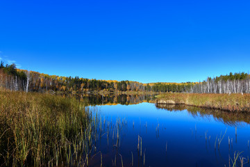 Calm Northern pond reflecting the sky up in Northern Saskatchewan