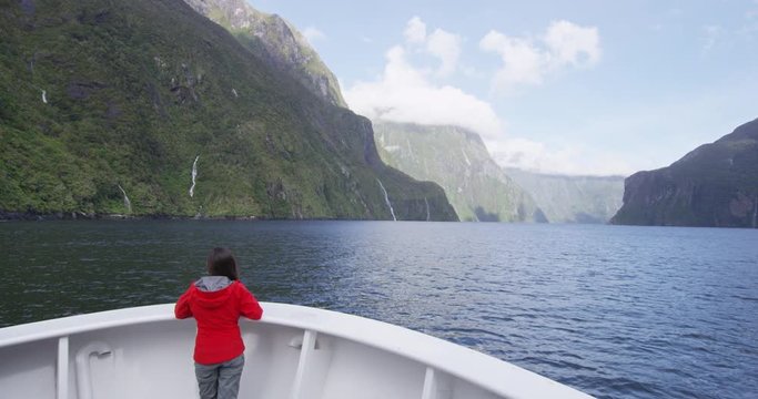 Cruise ship tourist on travel in New Zealand Milford Sound Fiordland National Park. Tourist enjoying boat tour and amazing view of fjord in most famous travel destination in New Zealand.