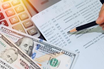 Obraz premium US dollar money,account book bank and calculator on table.