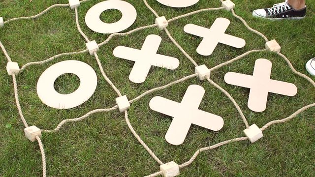 Two children play in a giant TIC TAC toe in summer camp. Close-up. Slow motion.