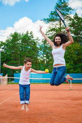 Naklejka premium Cute family or mother and son playing tennis and posing in court outdoor