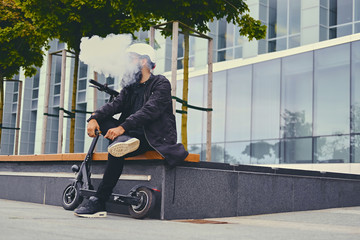A man vaping after electric scooter.