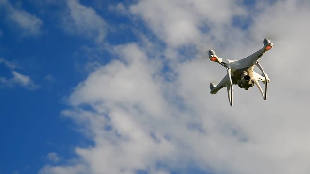 White unmanned aerial vehicle flies against a sky