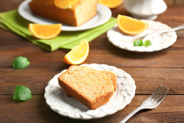 Plate with delicious sliced citrus cake on wooden table