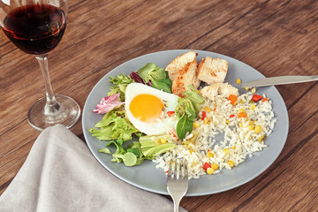 Delicious rice with meat, egg and mixed salad on plate on table