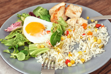 Delicious rice with meat, egg and mixed salad on plate on table