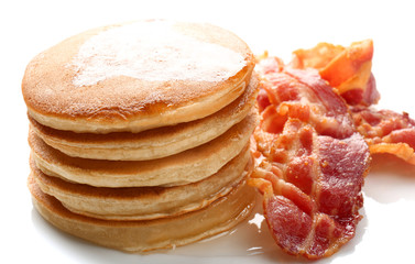 Tasty pancakes and bacon on white background