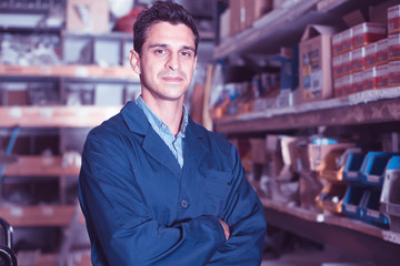 Portrait of friendly male in uniform on his workplace in building store.