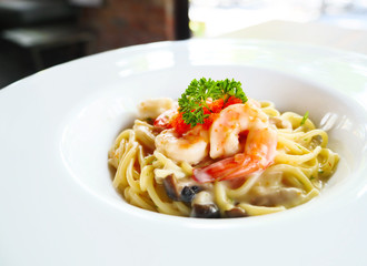 Spaghetti cream sauce with shrimp and mushroom on white dish, Spaghetti Ebiko cream. Selective focus.