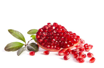 Part of a pomegranate with pomegranate seeds and leaves isolated on white background