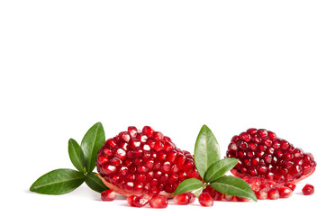Part of a pomegranate with pomegranate seeds and leaves isolated on white background