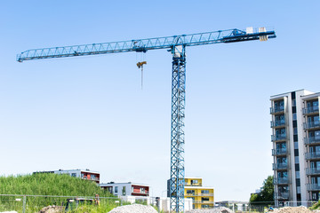 Fototapeta na wymiar Blue construction crane in sunny day on blue sky as a background
