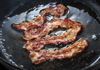 Cooked bacon rasher in a frying pan