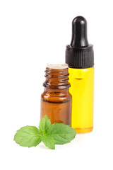 bottle of peppermint oil and fresh mint isolated on white background