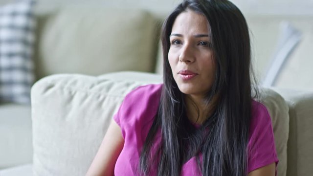 Tilt up of unrecognizable male HR manager writing notes on clipboard as expressive Hispanic woman talking during job interview