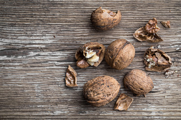 Walnuts on a wooden aged rustic background. Broken, crushed walnuts