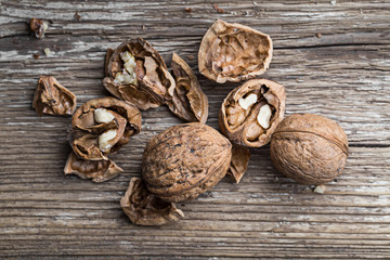 Walnuts on a wooden aged rustic background. Broken, crushed walnuts