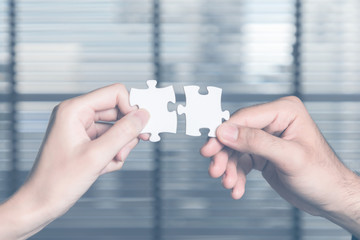business persons holding pieces of jigsaw puzzle. teamwork concept.