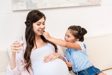 Girl feeding pill to mother