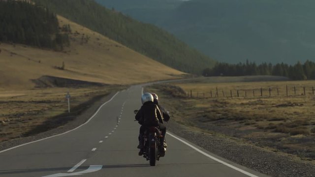Couple of Motorcyclists are Driving along a Mountain Road