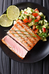 Lime Grilled Tuna with Avocado Cucumber Salsa closeup on a plate. Top view from above vertical
