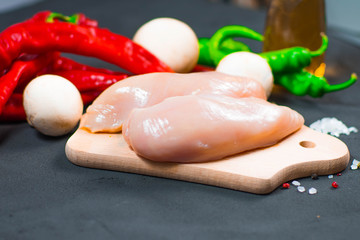 raw chicken wings with herbs in a transparent bowl Cauliflower with tomatoes and herbs and hot peppers