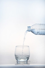 pouring water on a glass on white background
