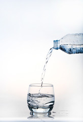 pouring water on a glass on white background