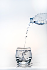 pouring water on a glass on white background