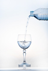 pouring water on a glass on white background