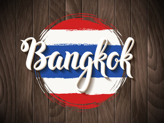 Naklejka premium Bangkok vector lettering and thai national flag on vintage wooden background. Bangkok city hand drawn typography. Vintage calligraphy design