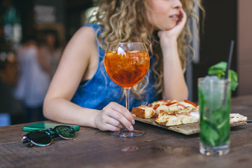 Detail of alcoholic drink of a beautiful young woman in a cafe during an aperitif