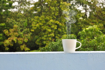 white hot coffee cup of green natural background