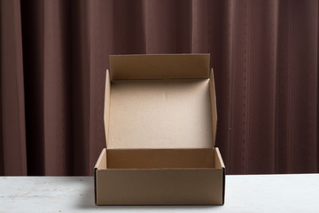 Opened cardboard box on wooden background