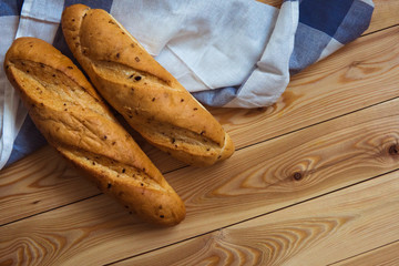 Two baguettes on a wooden background. Loafs on the table