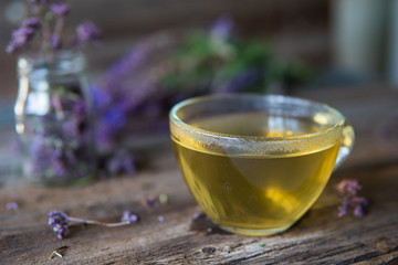 Green tea with herbals. Tea with oregano on the wooden background