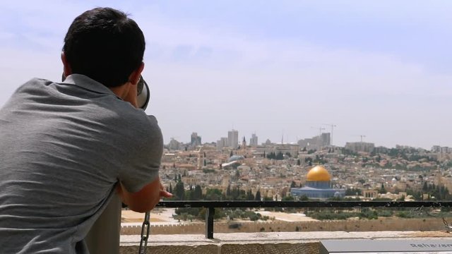 The guide shows the Jerusalem Old City view to the tourists and pilgrims. Mount of Olives is a famous Holy Land place and it has a fantastic view to the Old Jerusalem