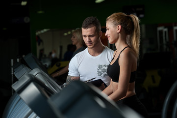 Obraz na płótnie Canvas Cute blonde woman working with fitness coach