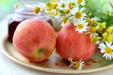 Two apples with chamomile on the plate