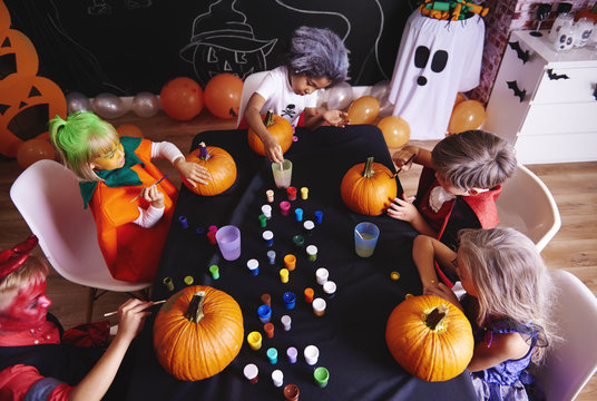 Kids painting a pumpkin for halloween