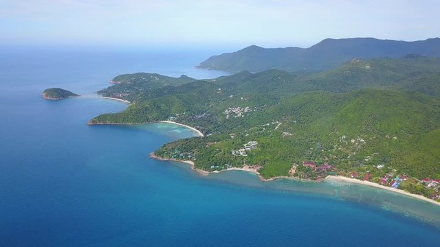 Aerial view of the mountain landscape and coastline of beautiful tropical island koh Phangan,Thailand. The chamber moves smoothly to the side showing the entire western part of the island